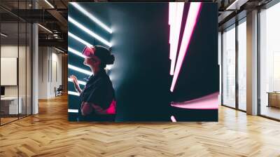 Girl using VR goggles in colorful neon lights, having fun. Wearable virtual augmented reality digital innovation technology concept Wall mural