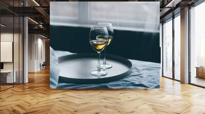 Glasses of white wine on bed in hotel room closeup. Wall mural