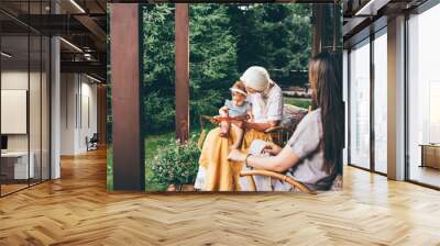 Happy multi-generation family relaxing on porch. Wall mural