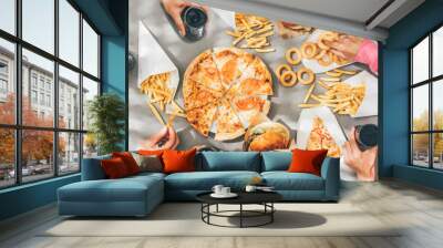 High angle view of friends eating burger and french fries at table in cafe. Wall mural