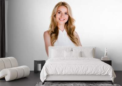 Real professional. Beautiful young woman looking at camera with smile while standing against white background Wall mural