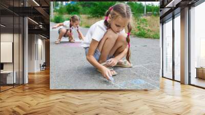 Sisters drawing rainbow with sidewalk chalk outside Wall mural