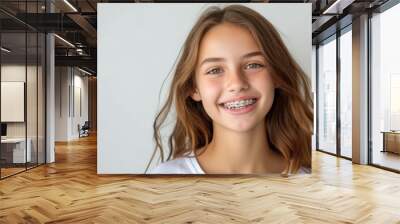 Joyful teenage girl with braces smiling against a white background Wall mural