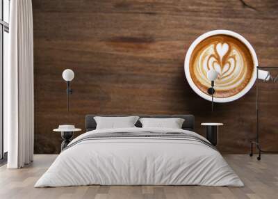 One cup of cappuccino with beautiful latte art on wooden brown background. Wall mural