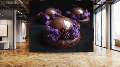 Glazed chocolate and blackberry desserts with purple microwave sponge and fresh berries on black velvet background Wall mural