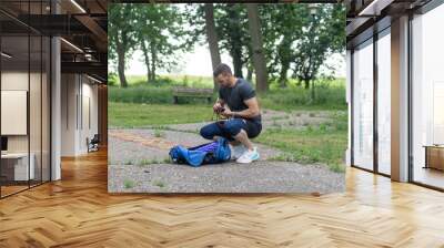 Man finishes training and returns sports equipment to gym bag.
 Wall mural