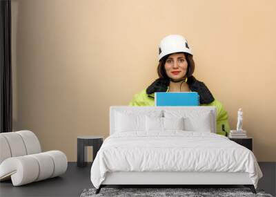 Female industrial worker in hard hat with document folder. Woman engineer with white hard hat. Climber Wall mural