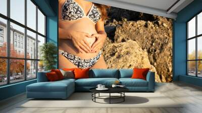 Young woman in swimsuit on second trimester of pregnancy. Expecting a child concept. Healthy pregnancy concept. Wall mural