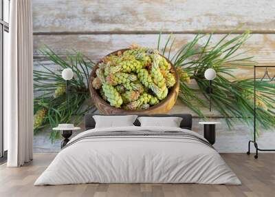 Pine buds in a wooden bowl on the table. Medicinal plants of folk medicine containing vitamin C are a means for the treatment of colds. Wall mural