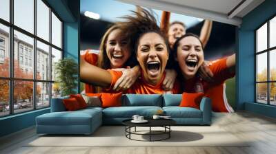 a group of female soccer players celebrating a goal on the soccer field. close view Wall mural