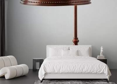 An old metal table lamp with a warm copper finish and a rounded, curved lampshade on a white background highlighting the elegant, vintage charm of the lamp. AI generated. Wall mural