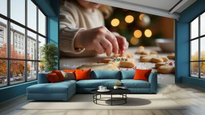 Child decorating Christmas cookies with colorful sprinkles on a table Wall mural