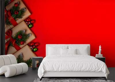 Christmas gifts in craft paper on a red background. Top view with copy space. Celebrating Christmas and New Years Wall mural