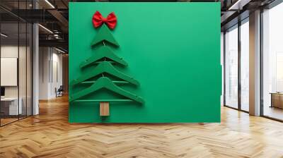 Christmas tree made of green hangers with a red bow on top Wall mural