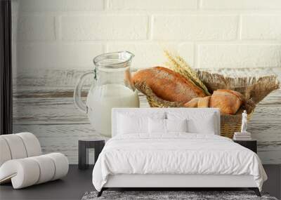 Composition of various baked products in basket on rustic background with jug of milk. Homemade fresh pastry. Wall mural