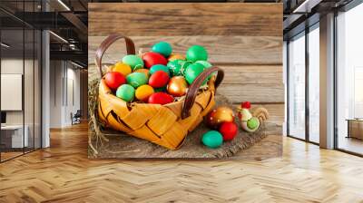 Hand-painted decorated Easter eggs in the basket on white wooden background, close up. Easter background Wall mural