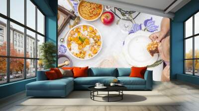 Little girl is eating pie. Family dinner in the courtyard outdoors. Autumn vegetables and fruits on the table. Dining table top view. A special place for text Wall mural