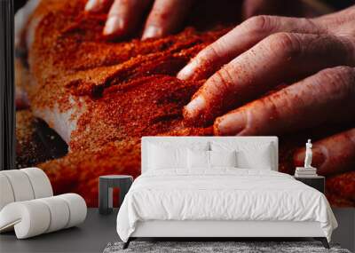 Man preparing raw piece of meat, rubbing different spices and herbs in it before roasting Wall mural