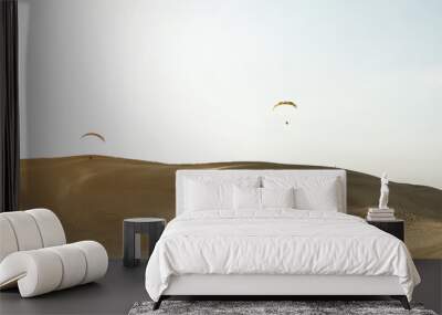 Two paragliders flying over sand dunes in Qatar desert Wall mural