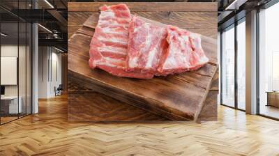 Pork ribs uncooked on wooden cutting board. Rusty style, close up Wall mural