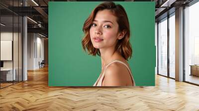 Portrait of a young woman with short hair against a green background for beauty and fashion Wall mural