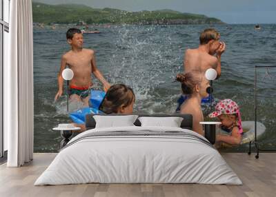 Caucasian children in the sea on the beach in summer Wall mural