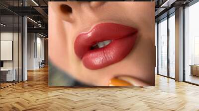 permanent makeup on the lips of a young woman of a delicate peach shade close-up, a girl after a cosmetic procedure with smooth and clean healthy skin. Wall mural