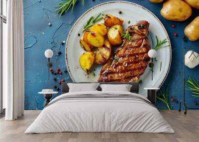 top view of pork steak with potatoes on a plate on a blue concrete background  Wall mural