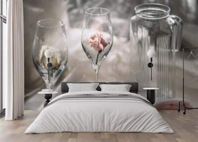 The jar and two empty glasses with dry roses on the table Wall mural