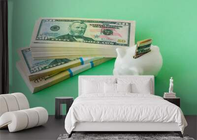 three bank packs of 50 dollars money on a green background with a piggy bank. the concept of finance and accumulation. Wall mural