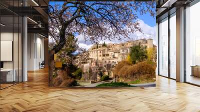 Vue sur le village de Lurs au printemps, Provence, France. Amandier en fleurs au premier plan. Wall mural