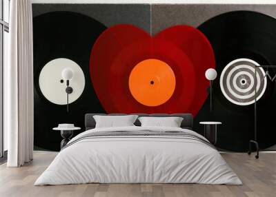 A red heart-shaped vinyl record between two black vinyl records for a turntable with a gray covers white wooden background of their boards. Listening to Christmas songs. Valentine's Day, Christmas Wall mural