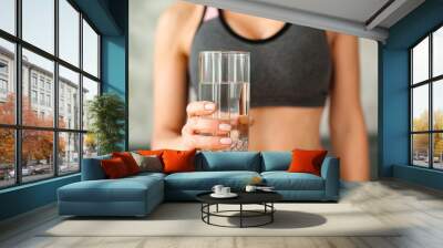 Woman in a tracksuit drinking a glass of water Wall mural