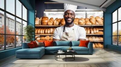 Smiling black male baker in white hat and apron on background of shelves with freshly baked bread and rolls in bakery store. Happy smiling baker sells his products. Copy space. Mock-up. Wall mural