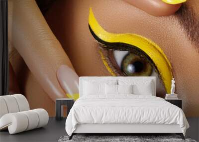 close-up female eye with bright yellow eyeliner makeup. neon disco make-up and fashion manicure. sum Wall mural