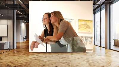 Captivated by a masterpiece. Shot of tow women enjoying a day in an art gallery. Wall mural