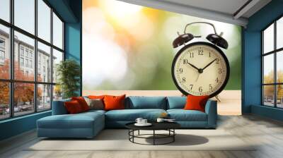 Retro alarm clock on table with green background Wall mural