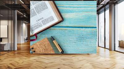 2 Kings open Holy Bible Book with a notebook and pen on a wooden background with copy space. Top table view. Old Testament Scripture study, biblical concept. Wall mural