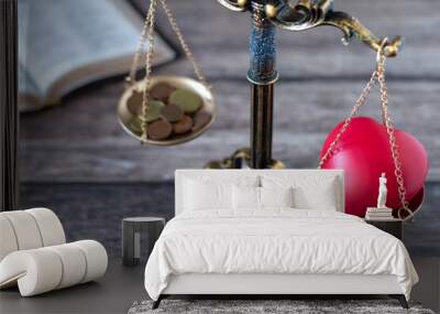 Balance scales with red heart shape and coins with holy bible book in the background. Selective focus. Christian priorities, justice, tithing, giving, love, or money concept. Wall mural