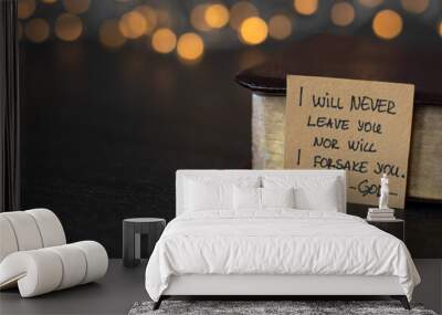 I will never leave you nor will I forsake you-God, handwritten verse on note and holy bible with golden pages with blurred golden bokeh background. Book of Hebrews 13:5 text. Wall mural