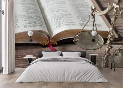 Old weighing scale balance on wooden table with Holy Bible Book in the background. Christian biblical concept of justice, fair judgment, and obedience to the Law of God Jesus Christ. A closeup. Wall mural