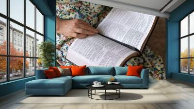 Senior Christian woman is reading and studying psalms in open holy bible book. Close-up. Selective focus. Biblical concept of wisdom, faith and obedience to God Jesus Christ. Wall mural