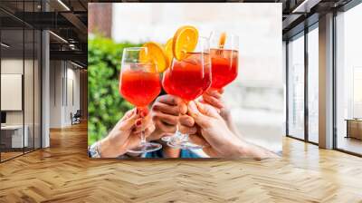 hands of group of friends toasting a red cocktail Wall mural