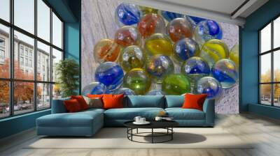 Blu, red, green, yellow glass marbles on clear background Wall mural