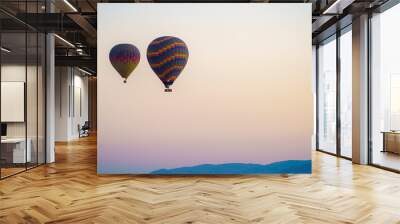 Colorful balloon flying over a clear sky during a sunset on a sunny day in Cappadocia, Turkey Wall mural