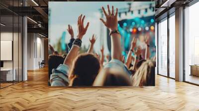 A cheerful crowd at an outdoor music festival during the day, with people dancing, singing along, and waving their hands in the air. Wall mural