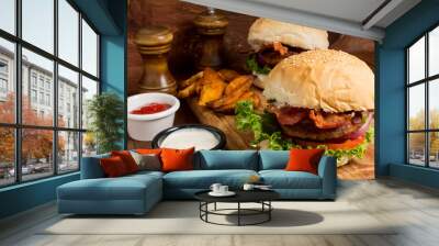 Gourmet Tasty Steak Burgers on a Wooden Tray with Potato Wedges Dipping Sauce and ketchup Wall mural