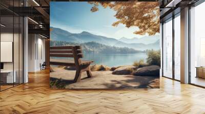 A wooden bench is placed by a lake, with mountains in the background Wall mural