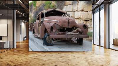 Rusty Abandoned Vintage Car with Severe Damage Parked on a Sidewalk
 Wall mural