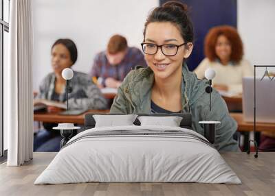 A solid education for a promising future. Portrait shot of a happy female student sitting at her desk. Wall mural